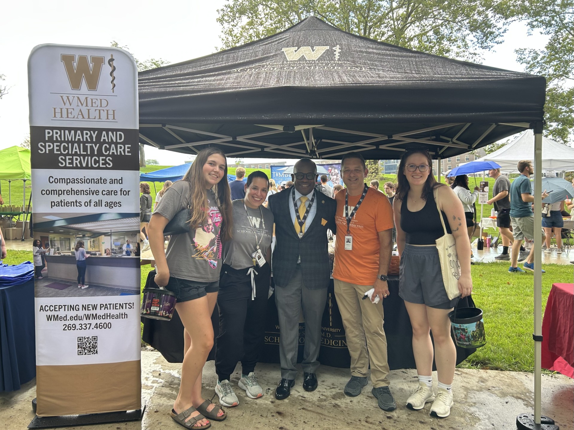 WMed Dean J. Adrian Tyndall smiles for a photo with WMU students and WMed Health clinical leaders