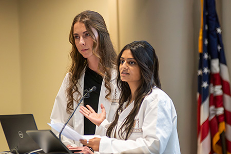 Second-year students Nayana Bhatnagar and Mackenzie Simon read the names of the 27 donors who were honored at the 2025 Donor Remembrance Ceremony