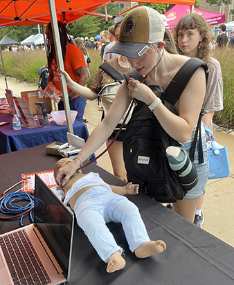 A WMU student listens to lung sounds on a high-fidelity manikin