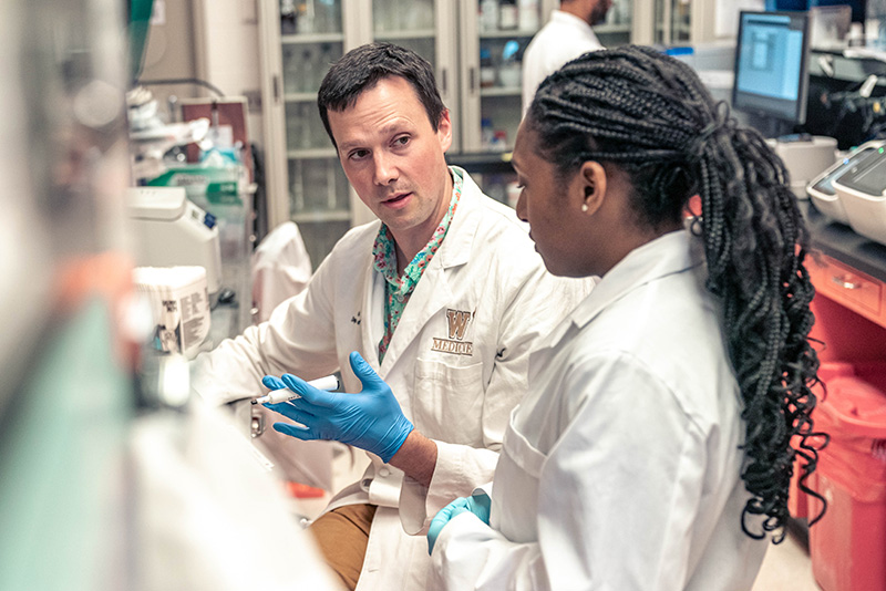 Postdoctoral fellow Joshua Mitchell, PhD, instructs students on procedures in the lab